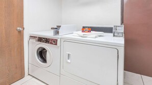 A front-loading washing machine with a control panel, a detergent box, and a dryer.