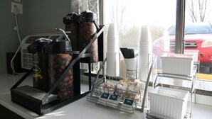 A coffee station with a coffee machine, grinders, and a coffee dispenser.