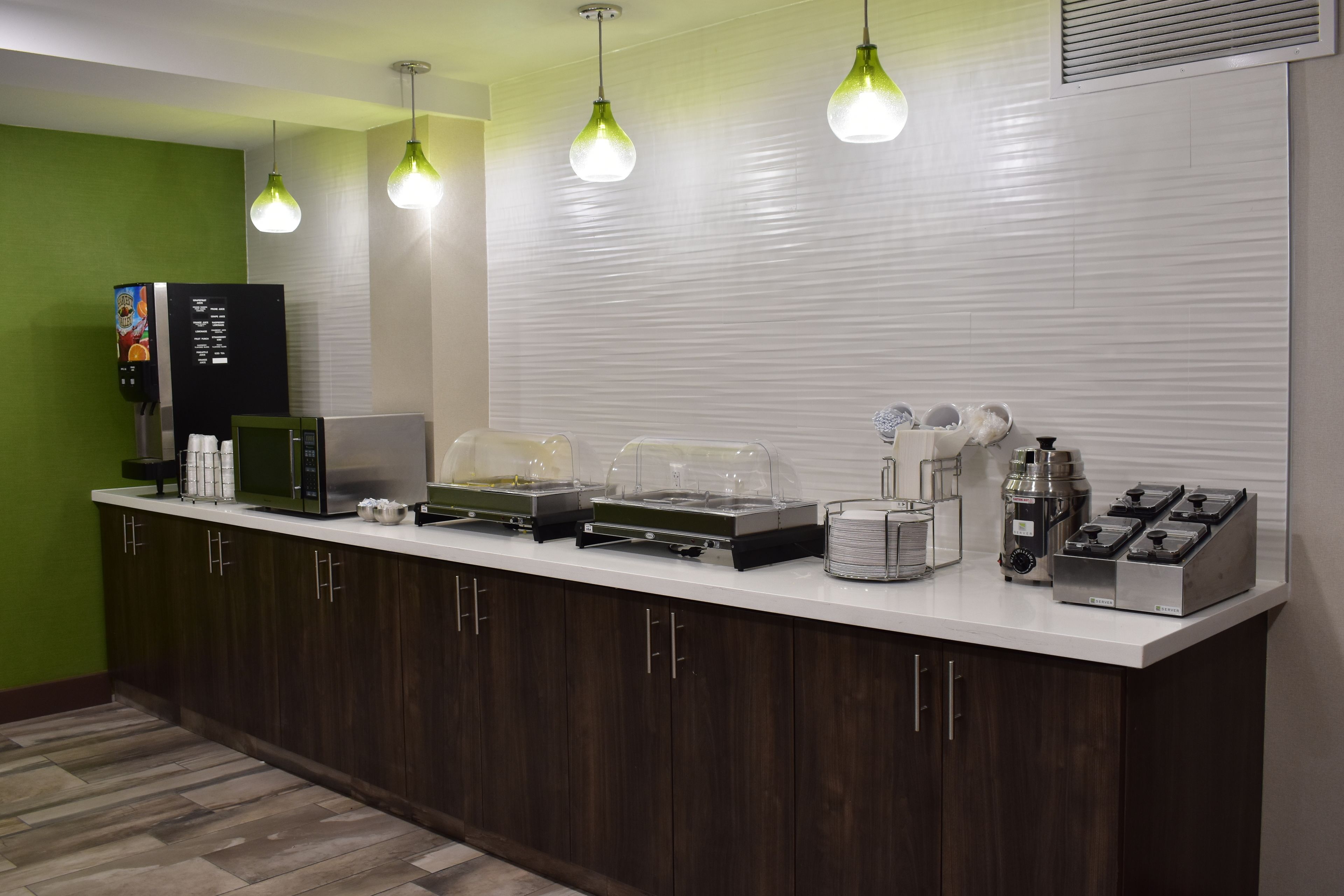 Una kitchenette con microondas, cafetera y dispensadores de alimentos.
