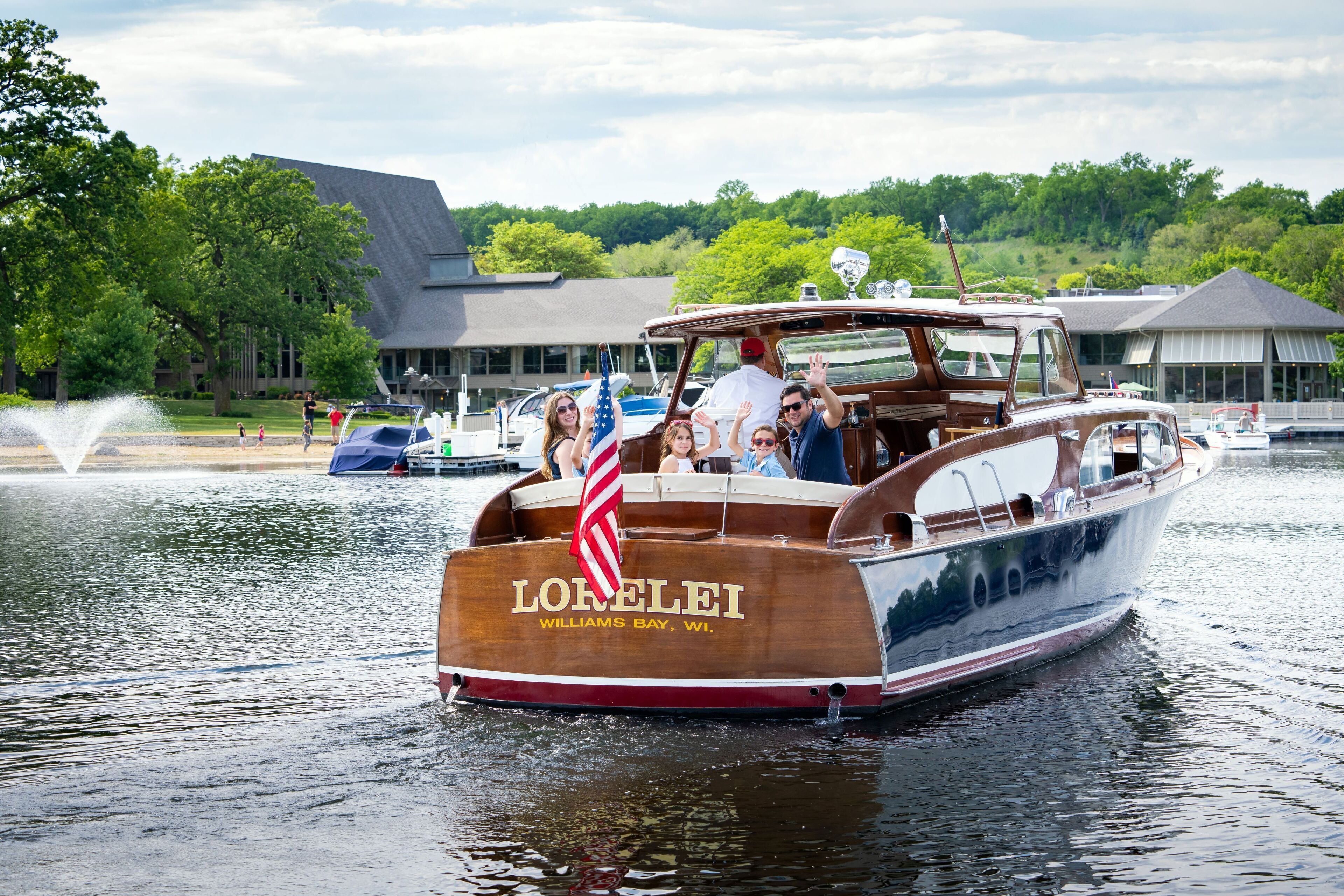 A wooden boat named "LORELEI" with "WILLIAMS BAY, WI" written on its side, floating on water.