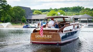 A wooden boat named "LORELEI" with "WILLIAMS BAY, WI" written on its side, floating on water.