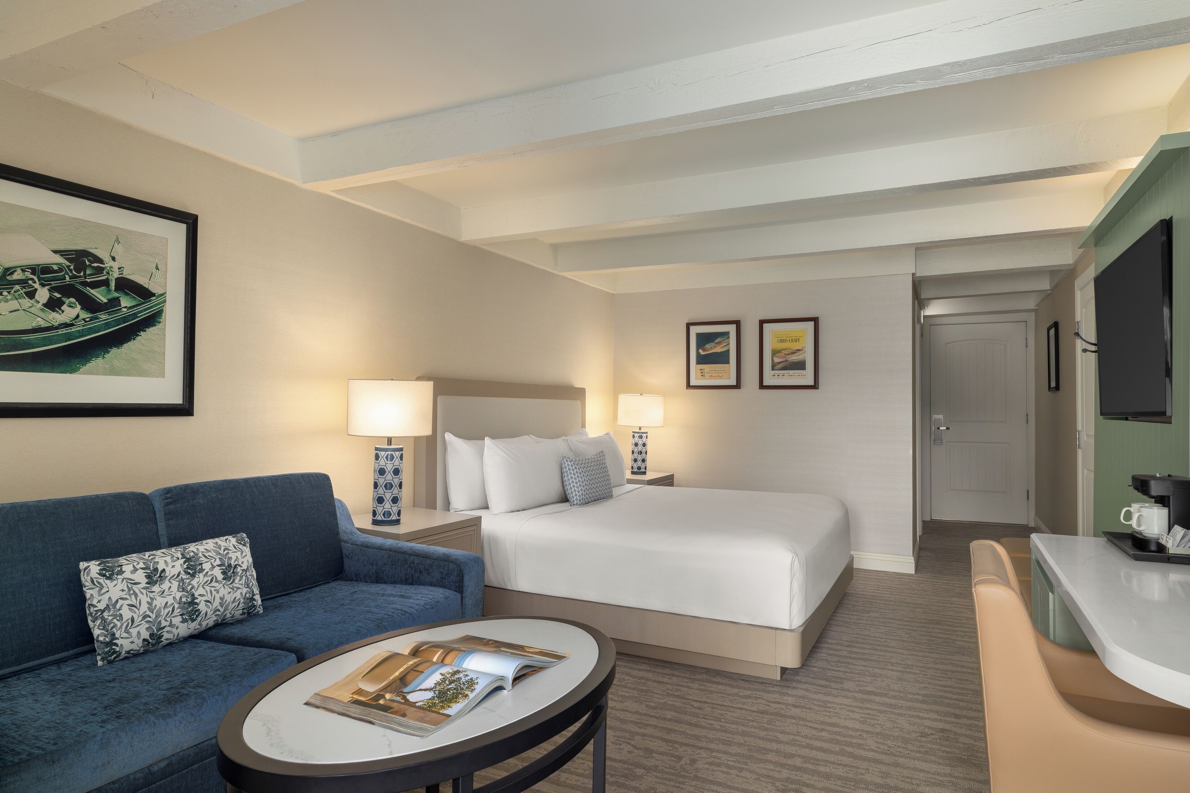 Una habitación de hotel con cama, sofá, una mesita y televisión.