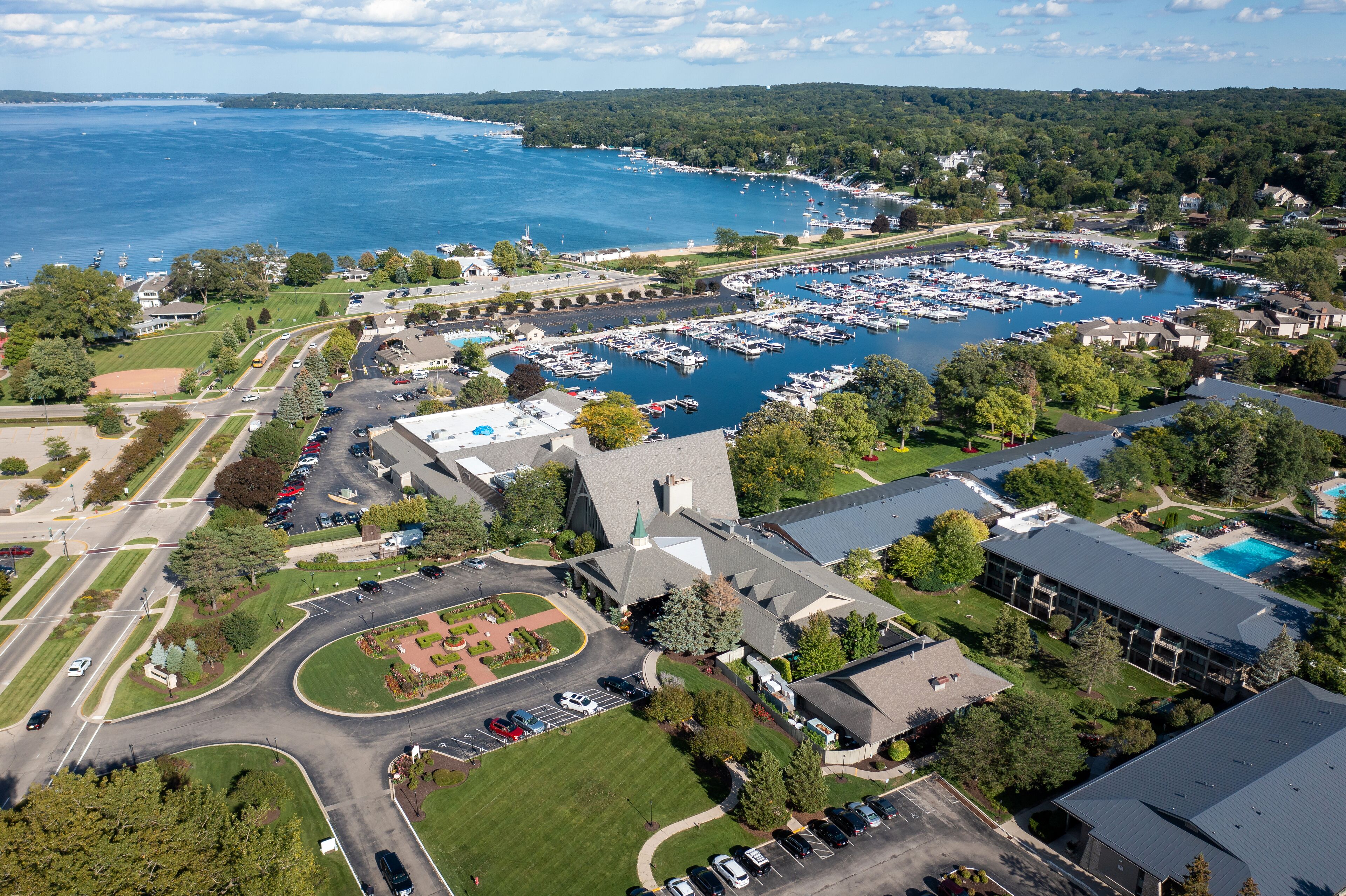 An aerial view of a marina with boats, surrounded by residential buildings and greenery.