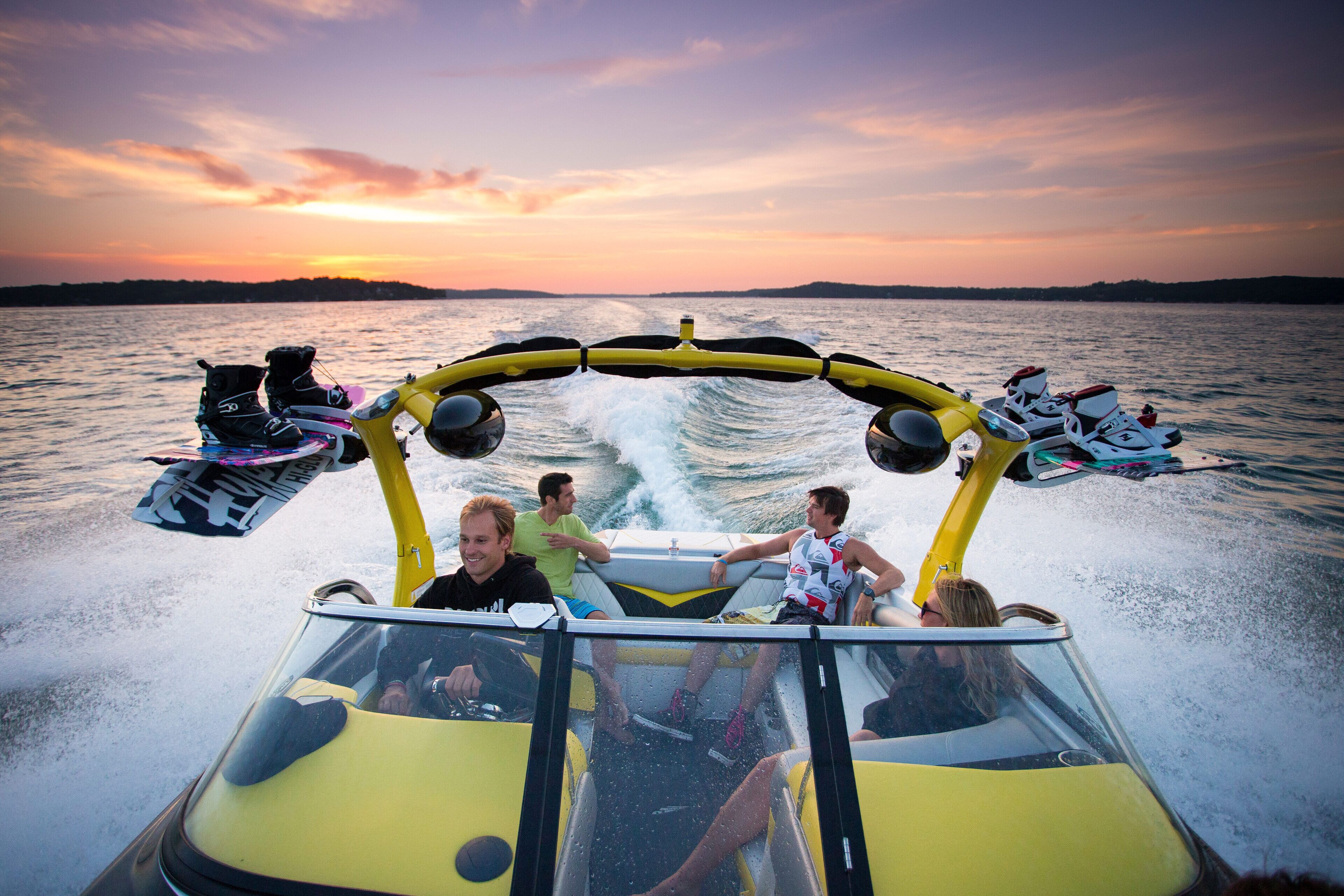 Un velero amarillo con pasajeros disfrutando de un paseo en el agua al atardecer.