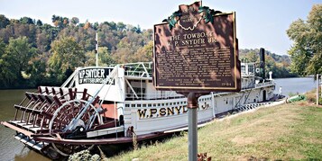 Un cartel histórico y un barco de remolque llamado W.P. Snyder Jr. en un río.