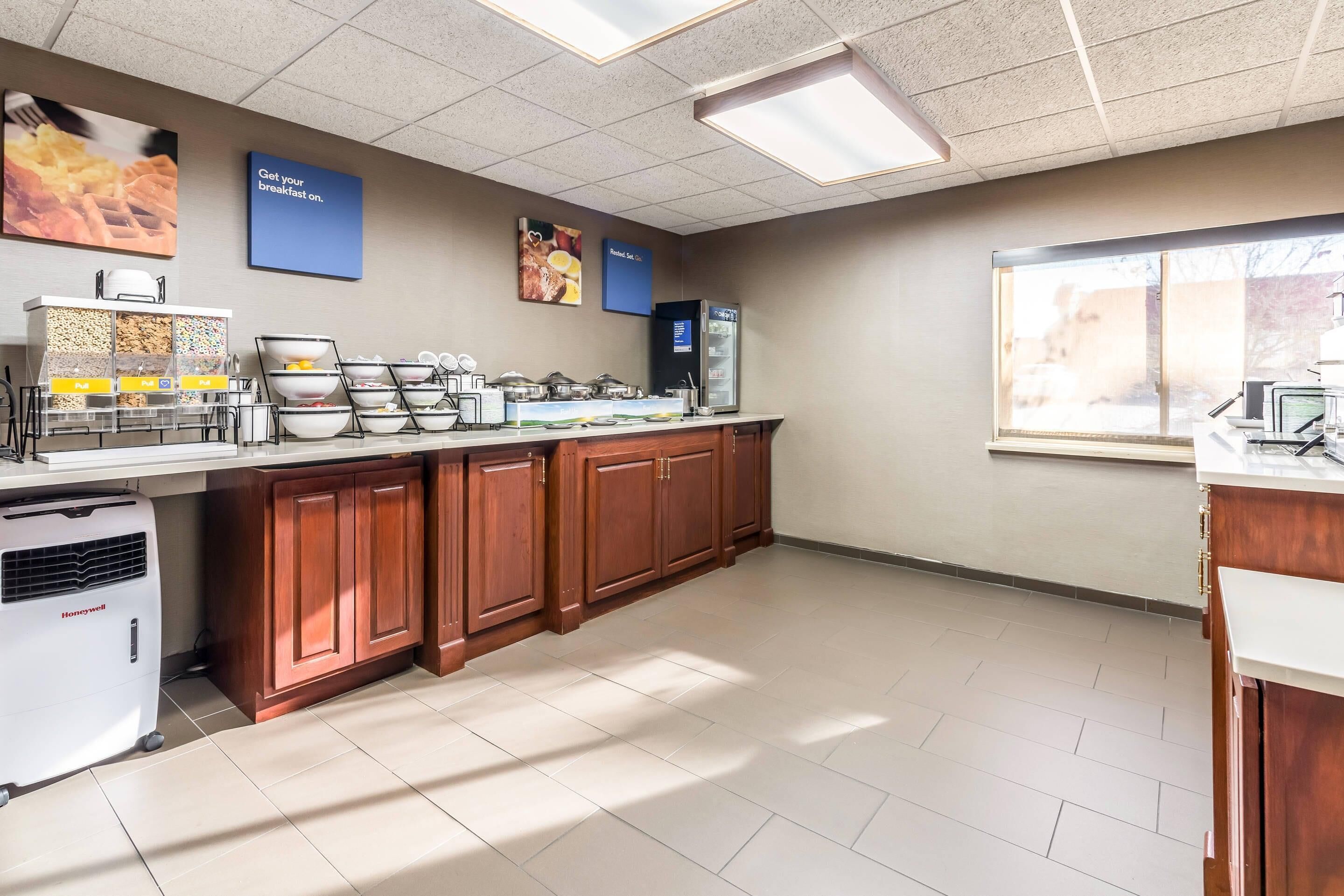 A kitchen with a food display, a Honeywell air conditioner, and a window with a view.