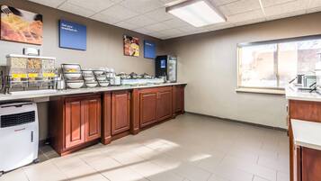 A kitchen with a food display, a Honeywell air conditioner, and a window with a view.
