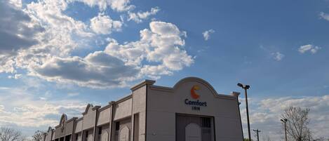 Edificio de Comfort INN con cielo despejado y nubes.