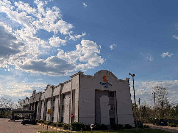 A Comfort INN building with a clear sky and clouds.