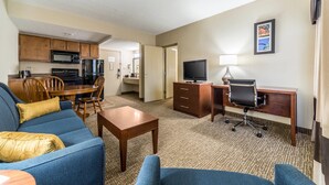 A hotel room with a living area, kitchenette, and a desk with a computer and chair. - Comfort Inn Festus - St Louis South (Festus)