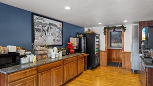 A kitchen with wooden cabinets, a microwave, a refrigerator, and a coffee machine. - Super 8 by Wyndham Jackson Hole (Jackson)