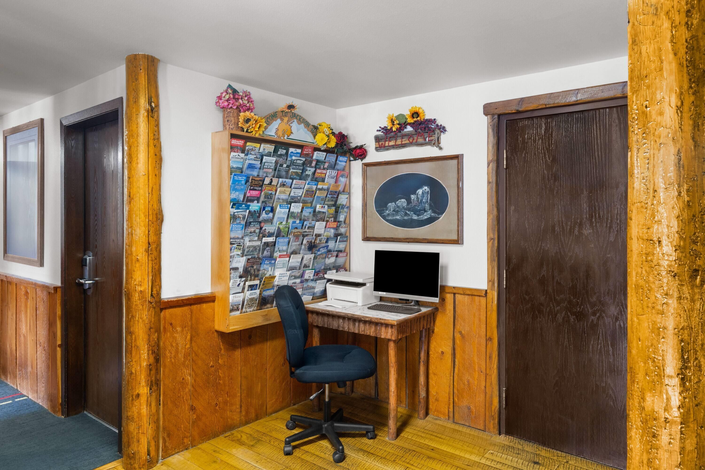 A home office with a desk, chair, and a wall of books.