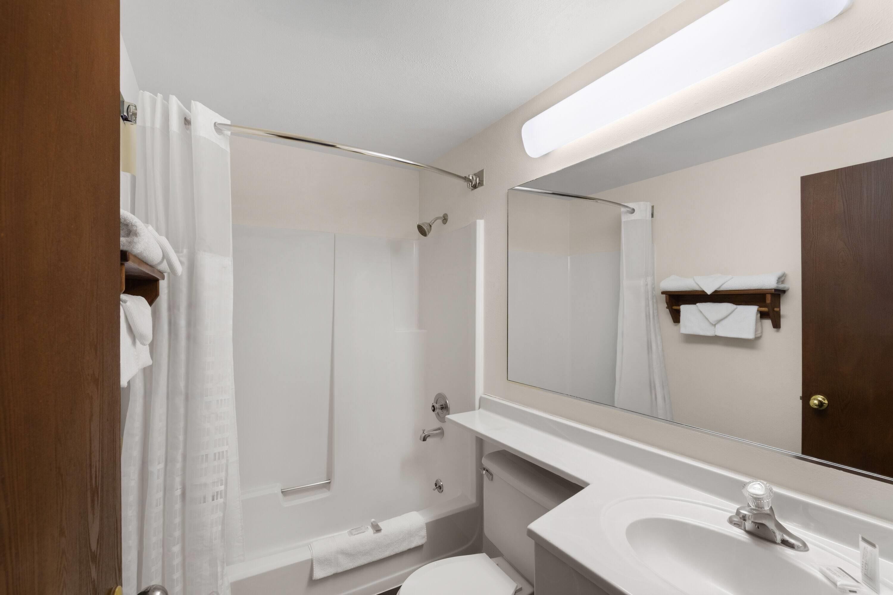 Un baño moderno con ducha, inodoro y lavamanos.
