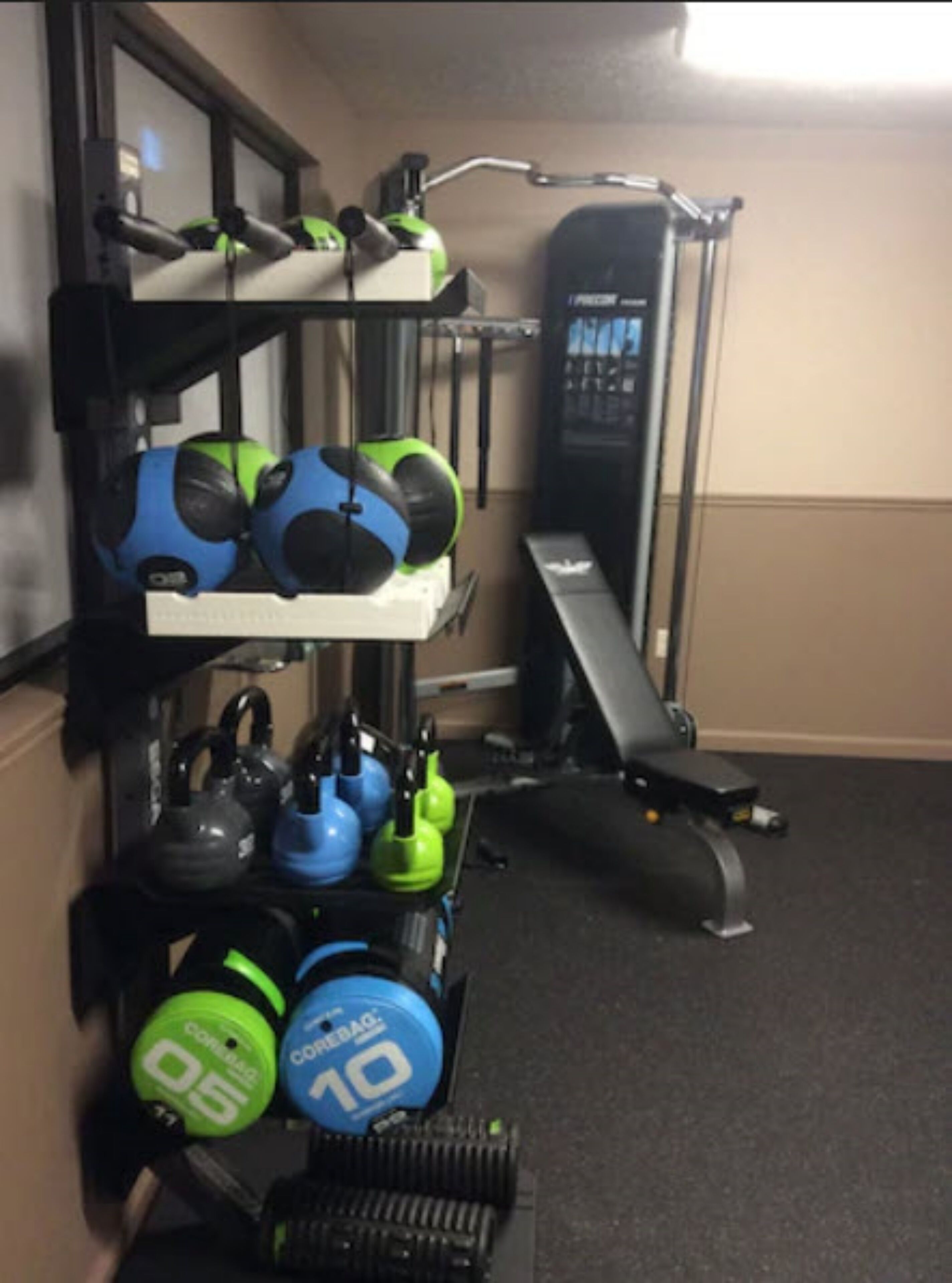A home gym with kettlebells, dumbbells, and a treadmill.