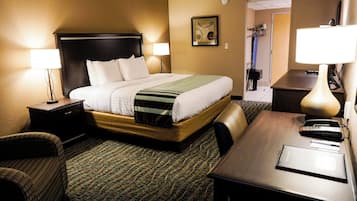 A hotel room with a bed, bedside tables, a desk, and a chair.