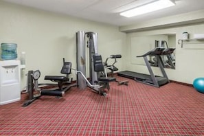 A fitness room with cardio equipment, a water dispenser, and a blue exercise ball. -  Economy Suites Springfield - I-44 (Springfield)