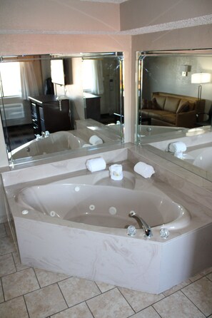 Suite, 1 cama de matrimonio grande, no fumadores, bañera de hidromasaje | Zona de estar | Televisión de pantalla plana de 32 pulgadas con canales por cable