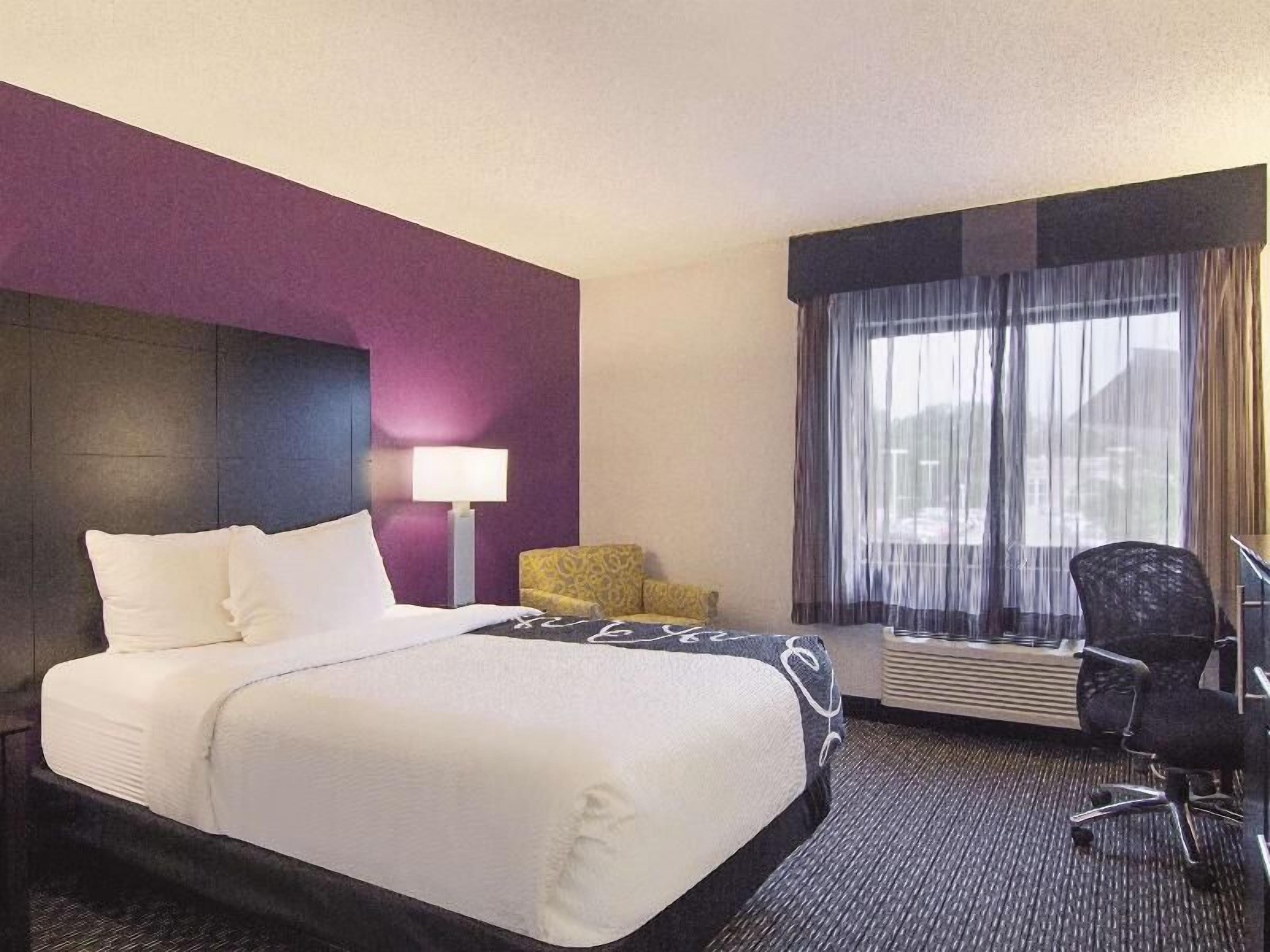 Premium bedding, desk, laptop workspace, blackout drapes