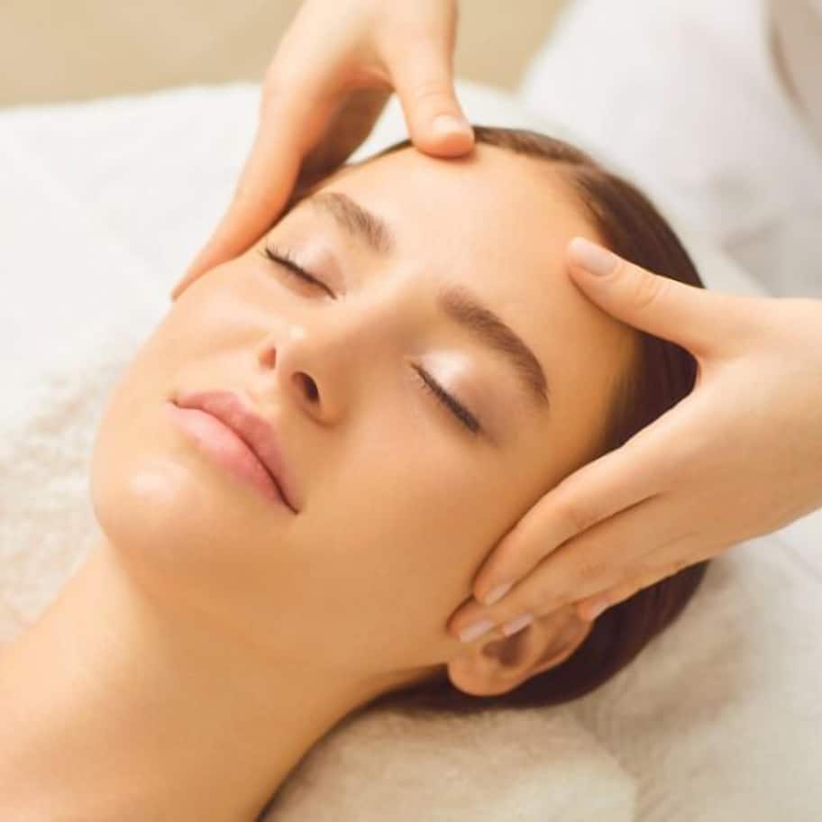 A person lying down with hands on their head, suggesting a massage or relaxation service.