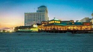 A beachfront hotel with a prominent building in the background and a well-lit structure in the foreground. - Resorts Casino Hotel Atlantic City (Atlantic City)