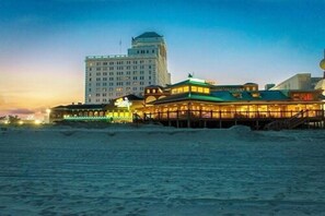 A beachfront hotel with a prominent building in the background and a well-lit structure in the foreground. - Resorts Casino Hotel Atlantic City (Atlantic City)