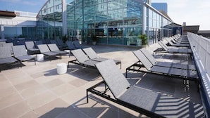 A rooftop lounge area with sun loungers and a glass building in the background. - Resorts Casino Hotel Atlantic City (Atlantic City)