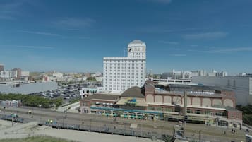 Un immeuble de grande hauteur doté d’une tour remarquable, une promenade en bord de mer bordée de boutiques et un parking.