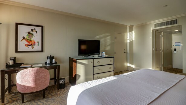 A hotel room with a bed, a desk with a chair, a television, and a framed picture on the wall. - Resorts Casino Hotel Atlantic City (Atlantic City)