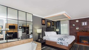 A modern hotel room with a large bed, a separate bathroom, a fireplace, and a large mirror. - Baymont by Wyndham Lancaster (Lancaster)