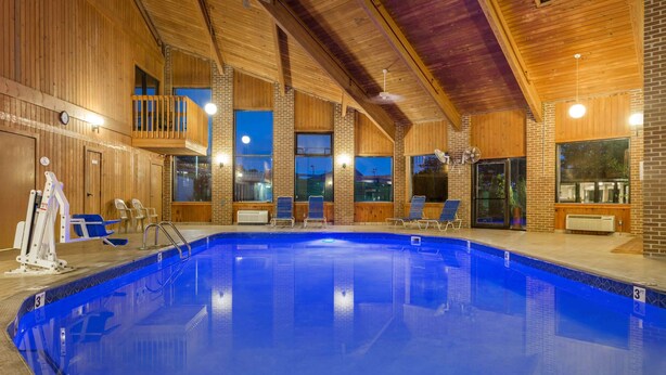 An indoor swimming pool with wooden walls and a balcony. - Baymont by Wyndham Lancaster (Lancaster)