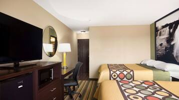 A hotel room with a TV, desk, chair, two beds, and a large painting on the wall.