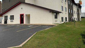 A multi-story hotel with a flat roof, a red door, and a parking lot in front. - Super 8 Springfield North I-44 (Springfield)