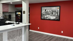 A reception area with a marble counter, a red wall with a Springfield, Missouri sign, and a glimpse of a kitchen area in the background. - Super 8 Springfield North I-44 (Springfield)