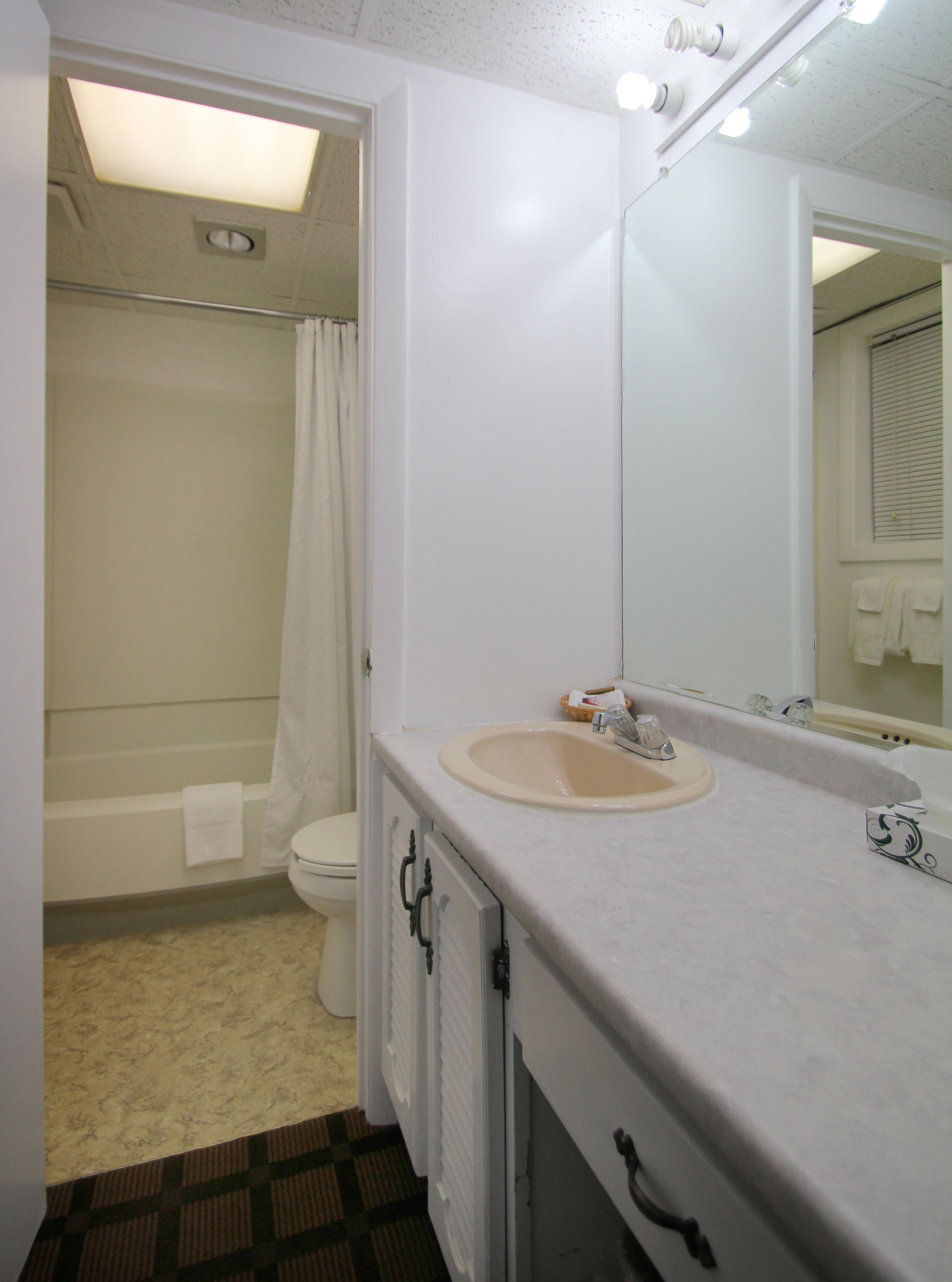 Un baño con inodoro, lavamanos y ducha.