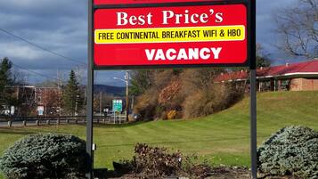 A sign for Eastgate Inn advertising a vacancy with amenities like continental breakfast, free WiFi, and HBO.