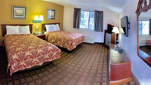 A hotel room with two beds, a dresser, a TV, and a window with curtains.