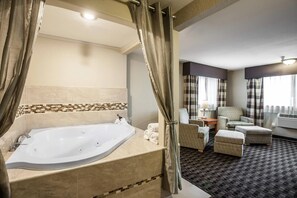 A bathroom with a bathtub, a shower curtain, and a seating area with a chair and ottoman.