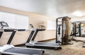 A gym with treadmills, a weight machine, and a mirror.