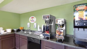 A kitchen with a coffee machine, a juice dispenser, and a dishwasher. - Super 8 by Wyndham Norfolk (Norfolk)
