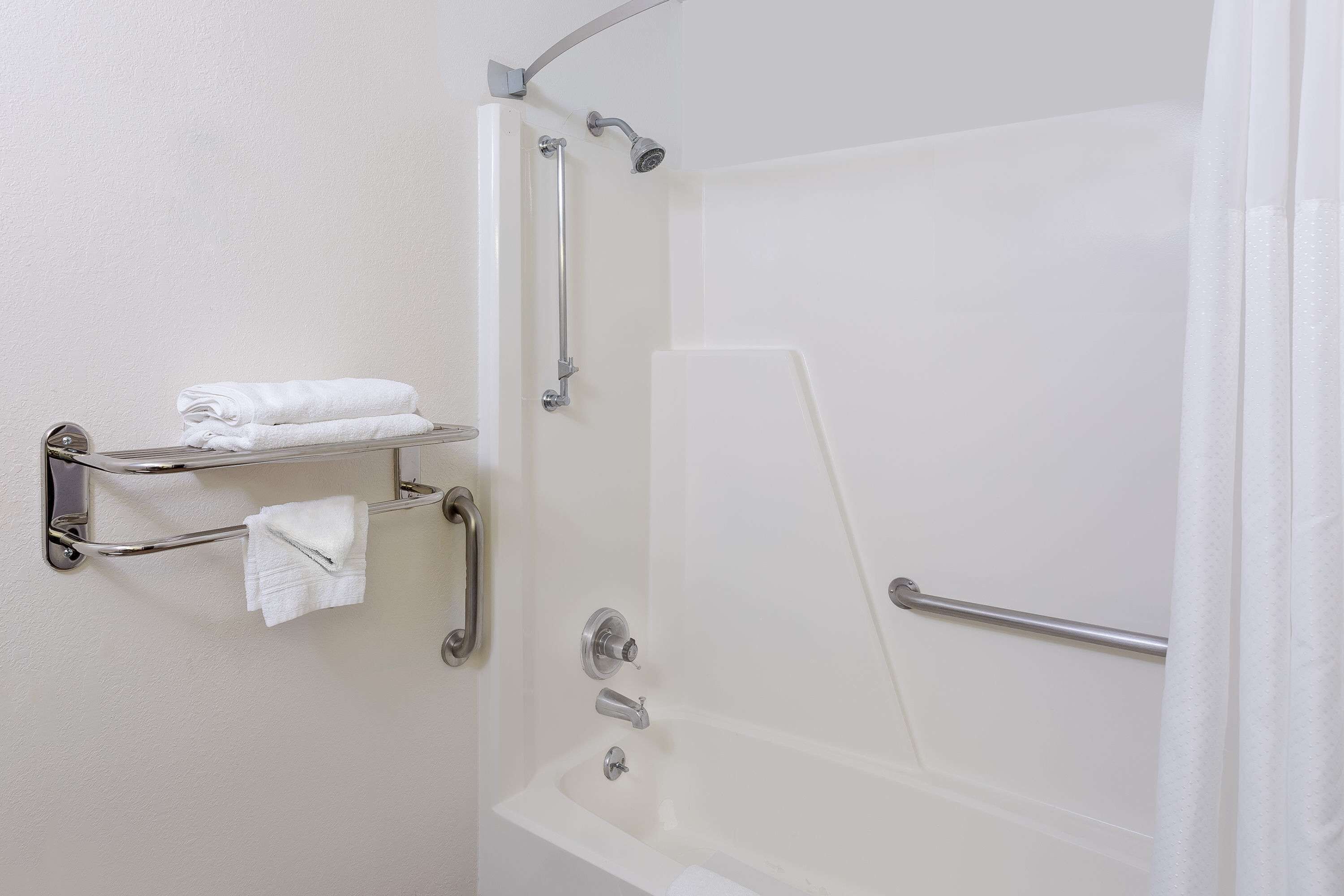 A modern bathroom with a bathtub, a shower, and a towel rack.