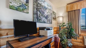 A wooden desk with a computer, a printer, and a plant. - Super 8 by Wyndham Cody (Cody)