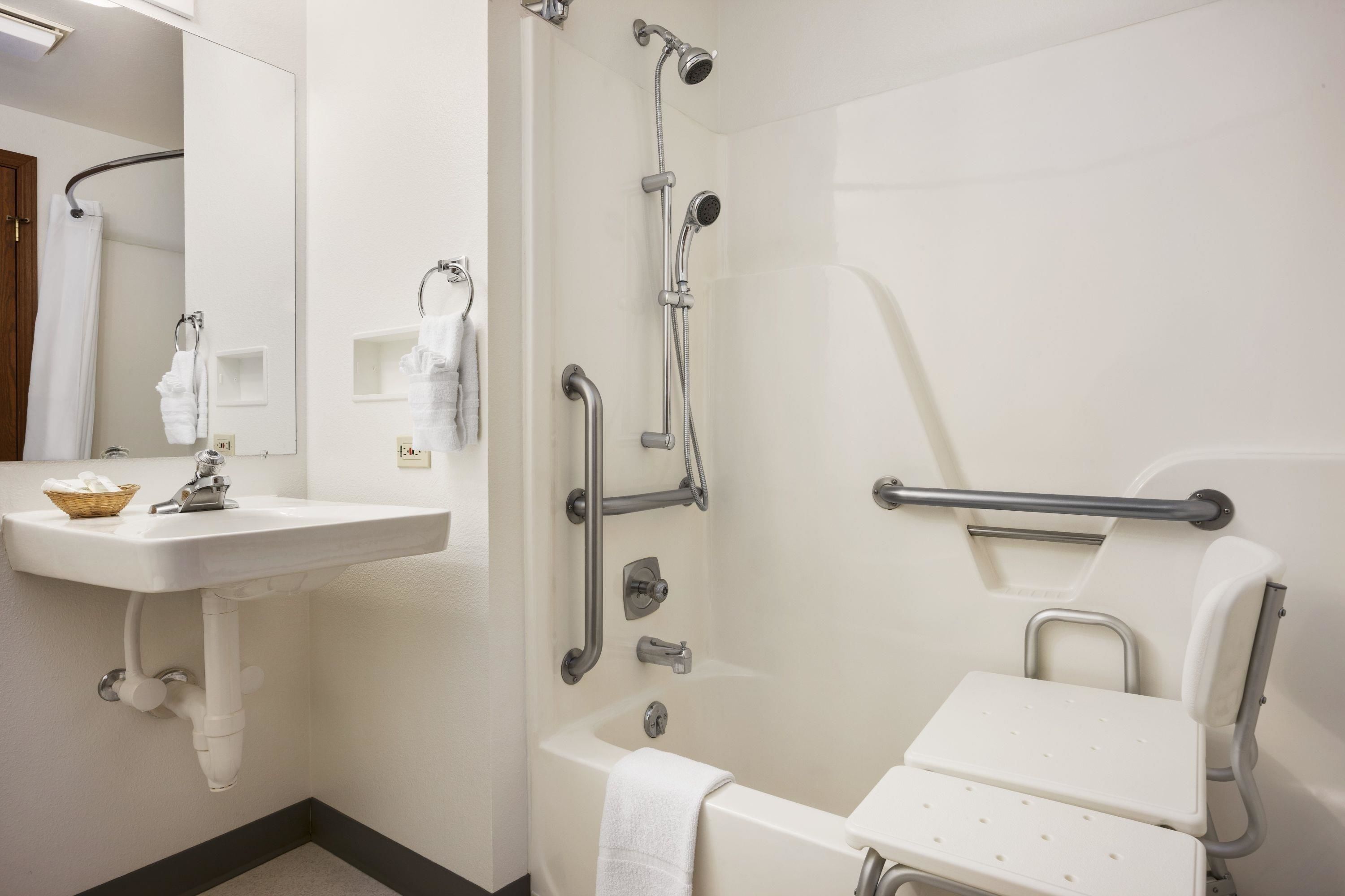 A bathroom with a sink, mirror, shower, and toilet.