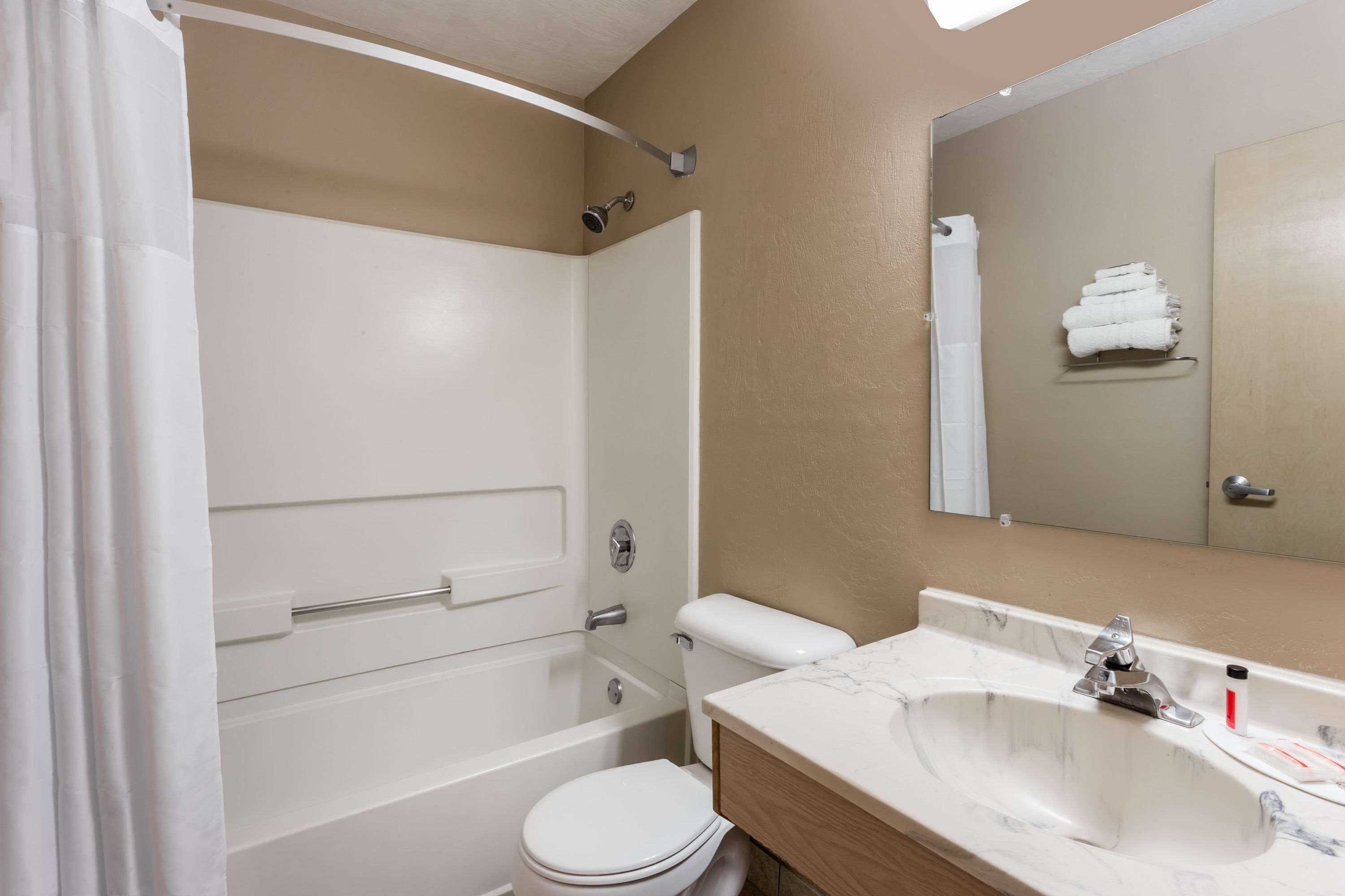 Un baño con bañera, inodoro y lavamanos.