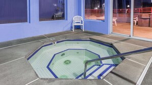 A swimming pool with a blue tiled border, a white chair, and a red railing. - Super 8 by Wyndham Corvallis (Corvallis)