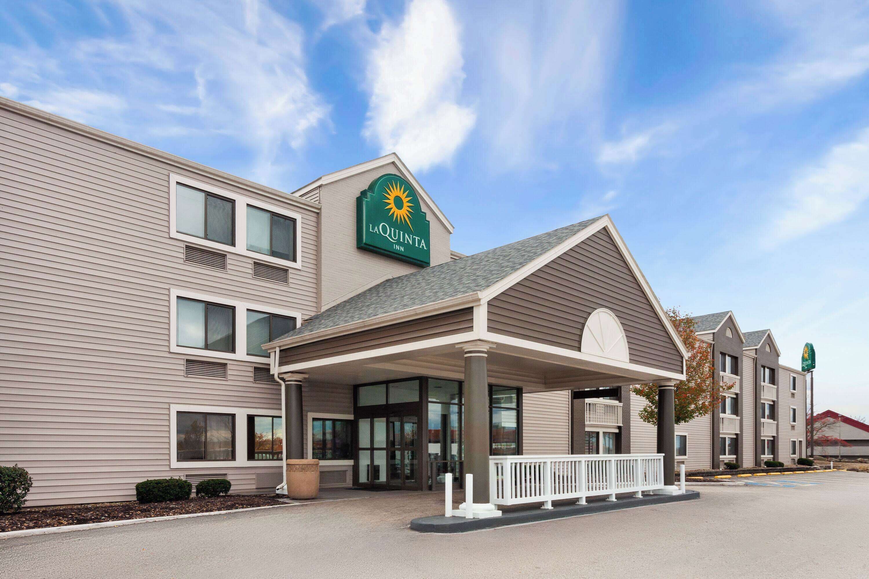 A La Quinta Inn with a covered entrance, multiple windows, and a clear sky.