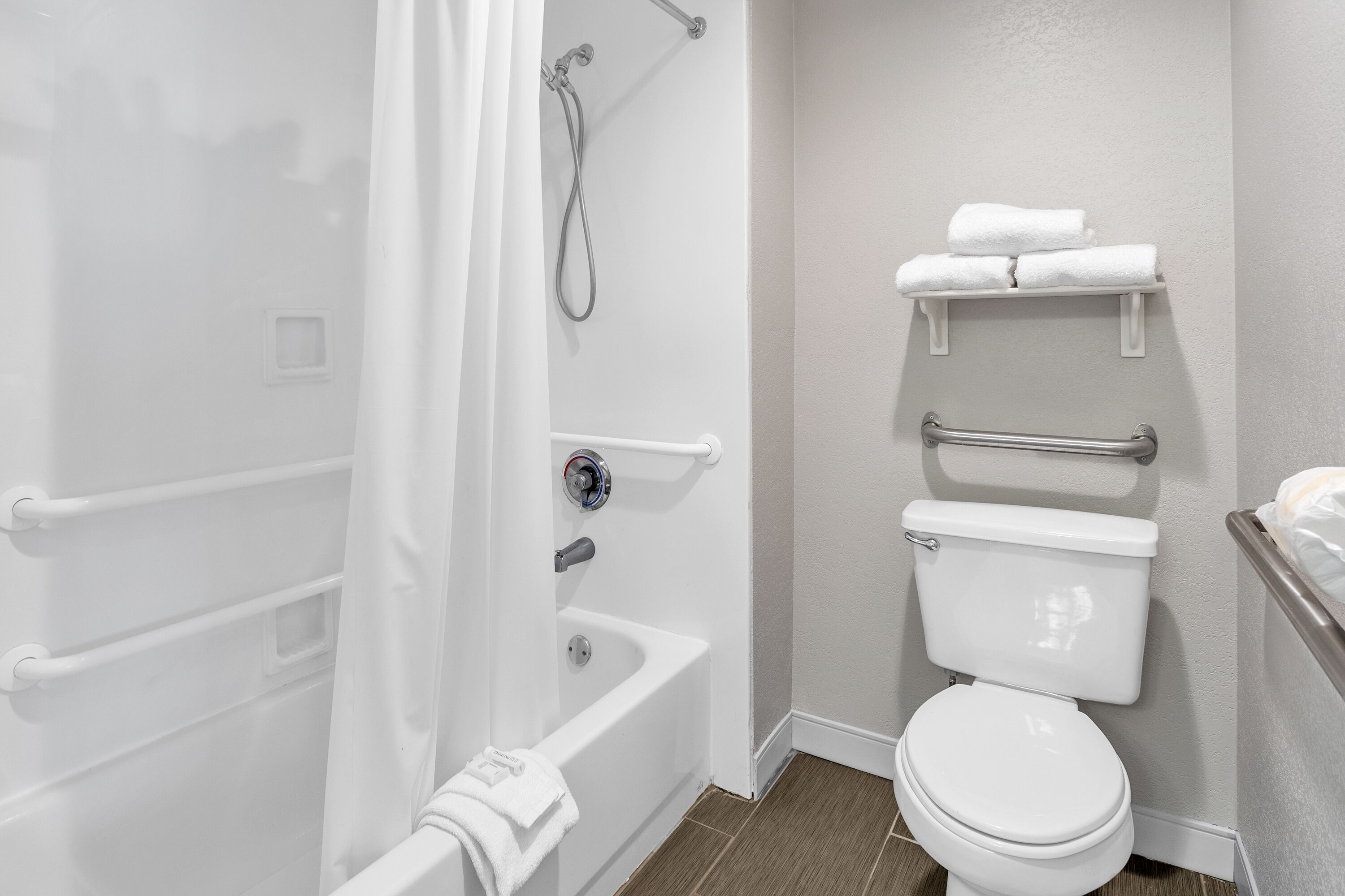 A bathroom with a bathtub, toilet, and shower.