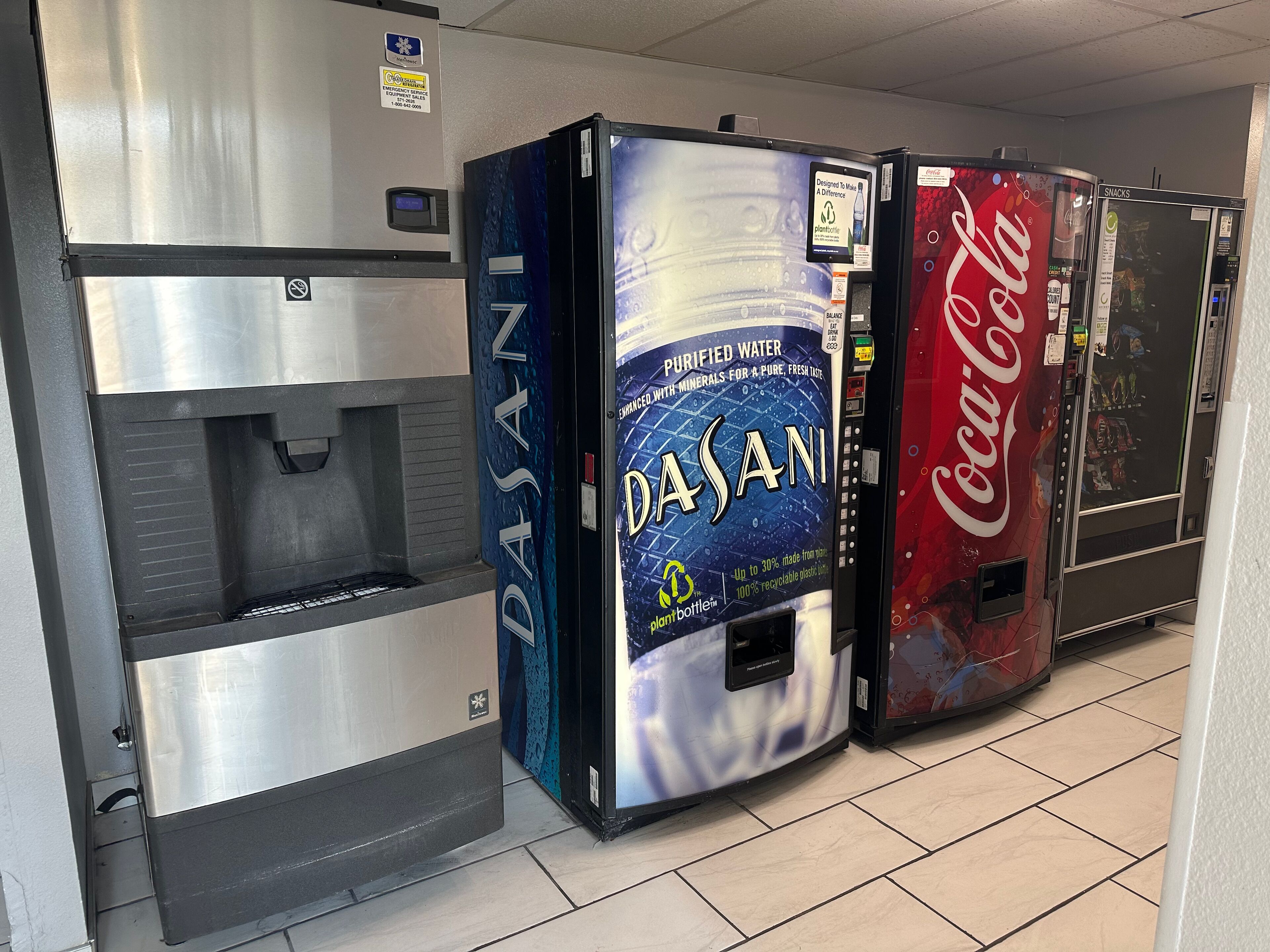 A row of beverage vending machines, including Dasani, Coca-Cola, and a water dispenser.