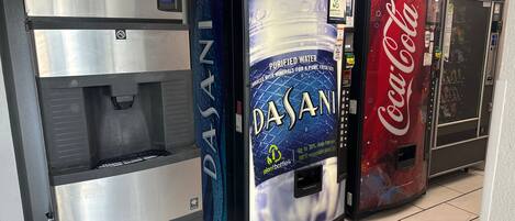 A row of beverage vending machines, including Dasani, Coca-Cola, and a water dispenser.