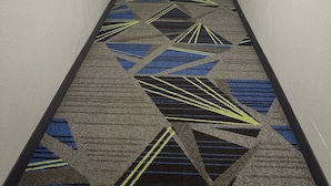 Un pasillo de hotel con pisos alfombrados y puertas a ambos lados.