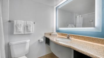 Uma casa de banho moderna com sanita, lavatório e espelho.